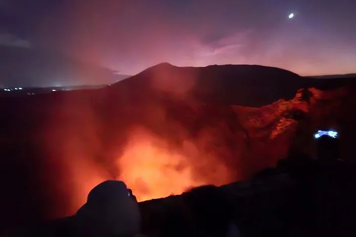 Looking into the brightly glowing crater of Masaya Volcano at night.